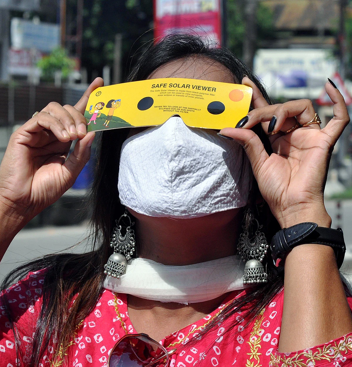A woman views solar eclipse using a filter in Guwahati on Thursday.