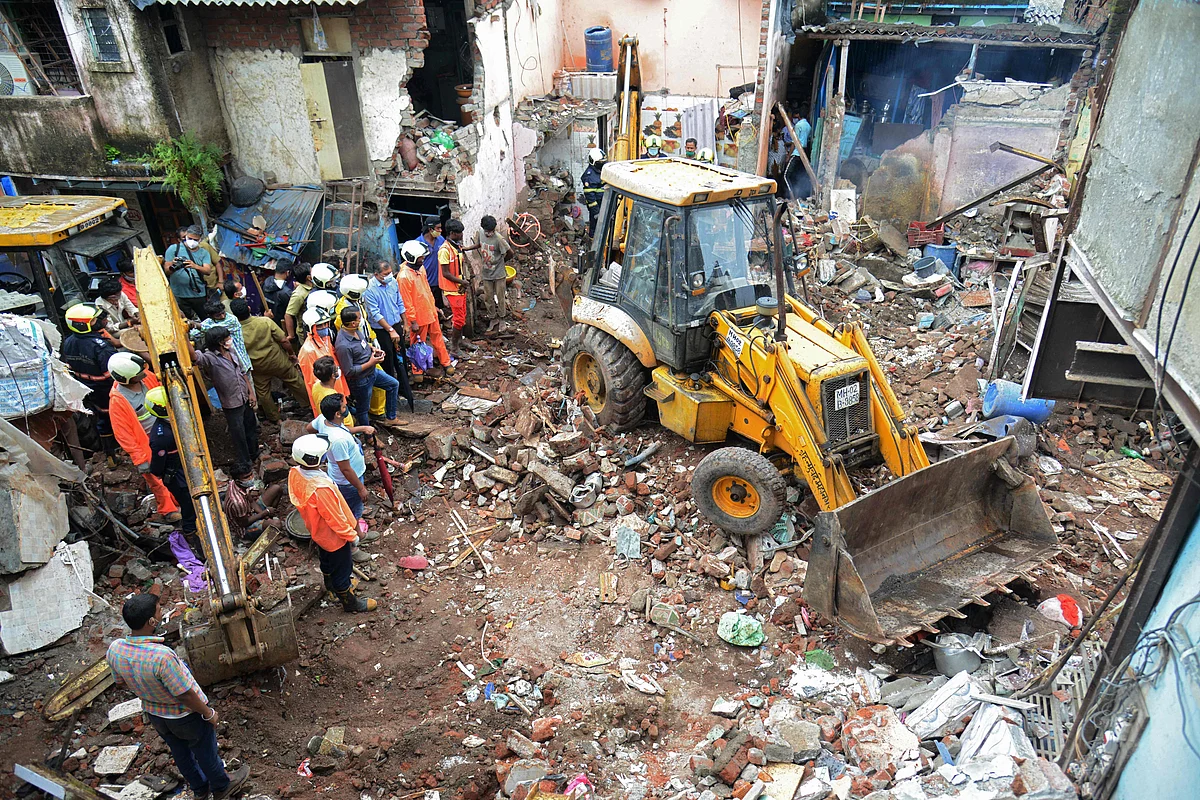 Civil authority and rescue personnel search for survivors in the debris of a building that collapsed following heavy monsoon rains, in Mumbai on June 10, 2021.