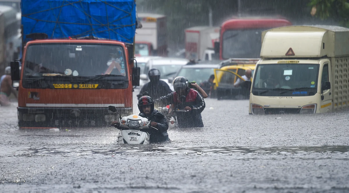 Vehicles make their way through the waterlogged road during heavy rain, at Kings Circle, in Mumbai, Wednesday, June 9, 2021