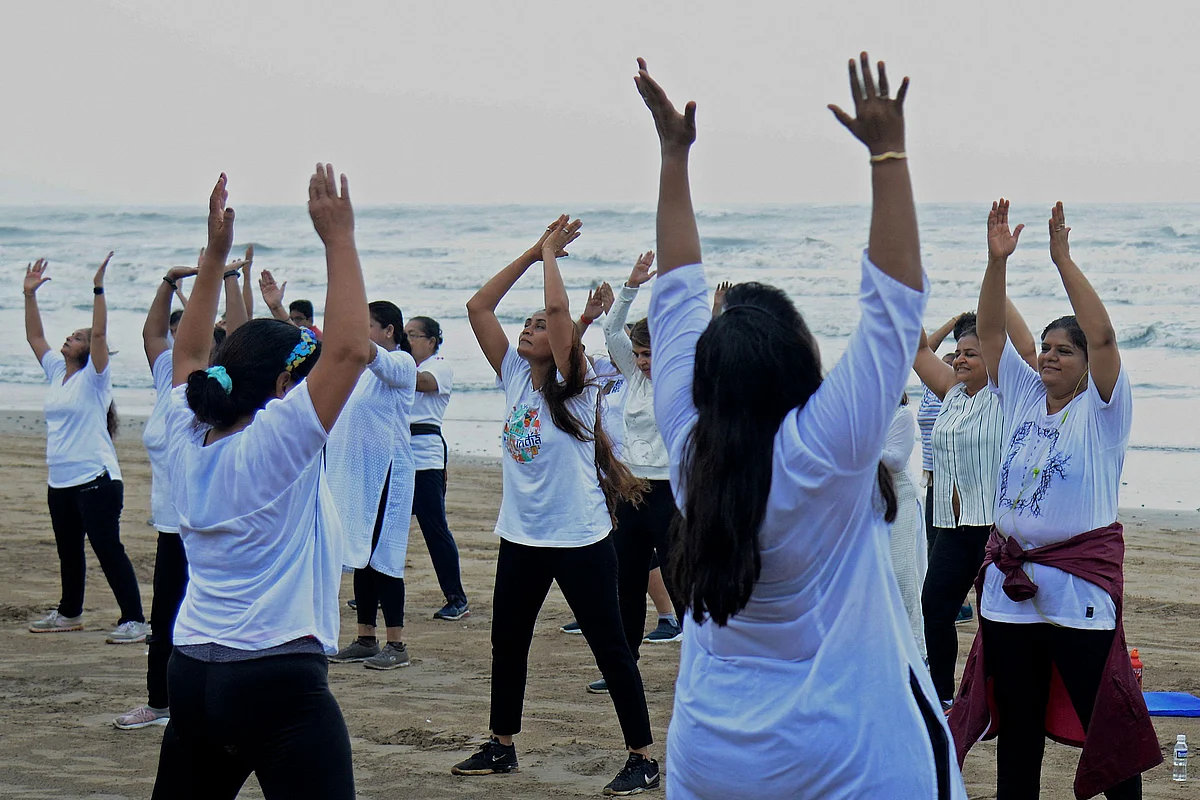 People take part in a yoga session at the Juhu beach of Mumbai on June 21, 2021, to mark International Yoga Day.