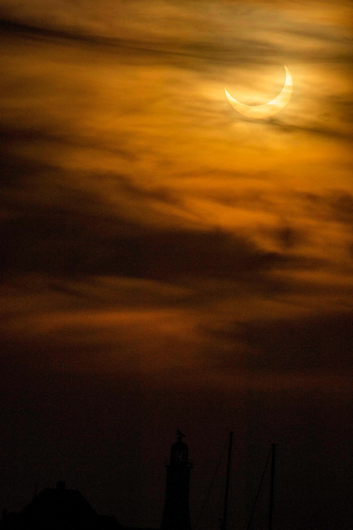 A annular (partial solar) eclipse is seen as the sun rises over Scituate Lighthouse in Scituate, Massachusetts on June 10, 2021.