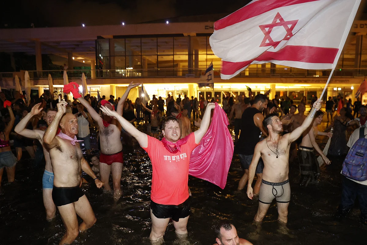 Israeli celebrate the passing of a Knesset vote confirming a new coalition government during a rally in Rabin Square in the Mediterranean coastal city of Tel Aviv on June 13, 2021.