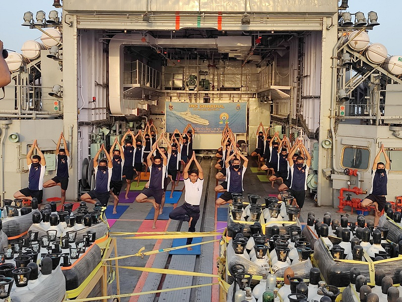 Indian Navy personnel perform Yoga on INS Shardul that is heading back from the Persian Gulf as part of the Operation Samudra Setu II deployment on the occasion of International Yoga Day 2021.