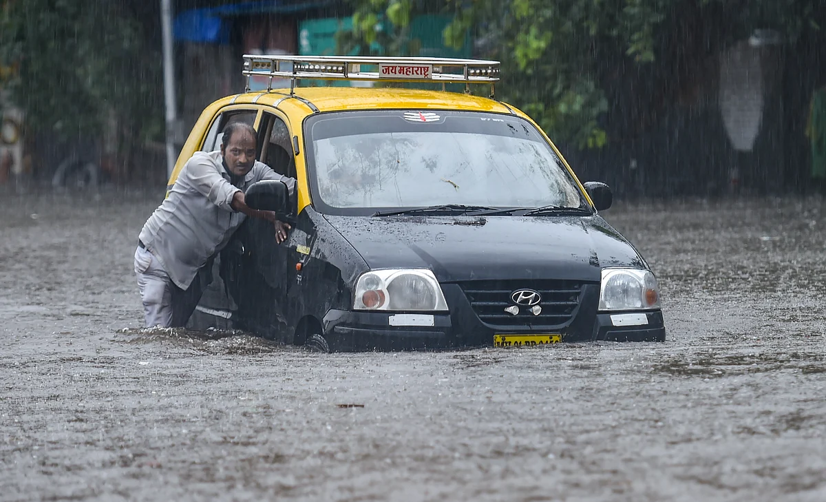 A taxi driver pushes his car as he tries to wade through a waterlogged street at Hindmata in Mumbai, Wednesday, June 9, 2021.