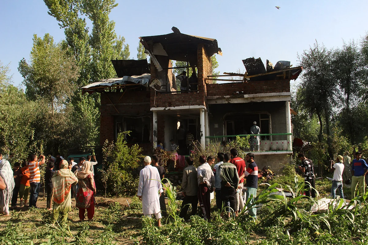 Kashmiri villagers gathered around a damaged house where a gun-battle occured between suspected militants and government forces in the Maloora locality on the outskirts of Srinagar in Jammu & Kashmir.