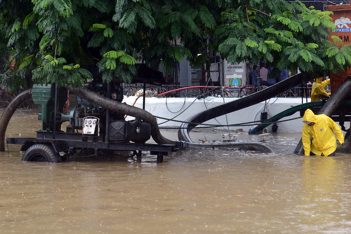 Municipal workers use a water pump to drain weater of a waterlogged road during a heavy monsoon rainfall in Mumbai on June 9, 2021.