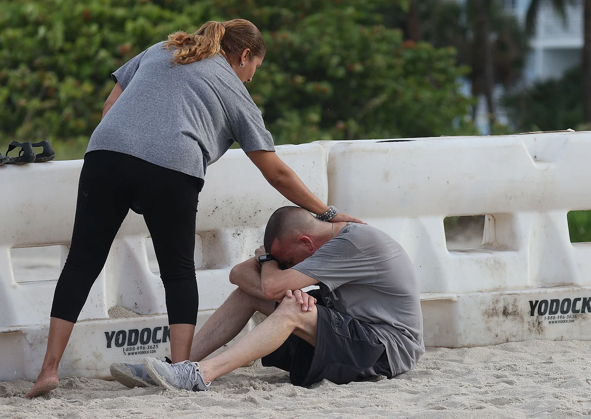A couple becomes emotional as they visit pray near the partially collapsed 12-story Champlain Towers South condo building on June 26, 2021 in Surfside, Florida.