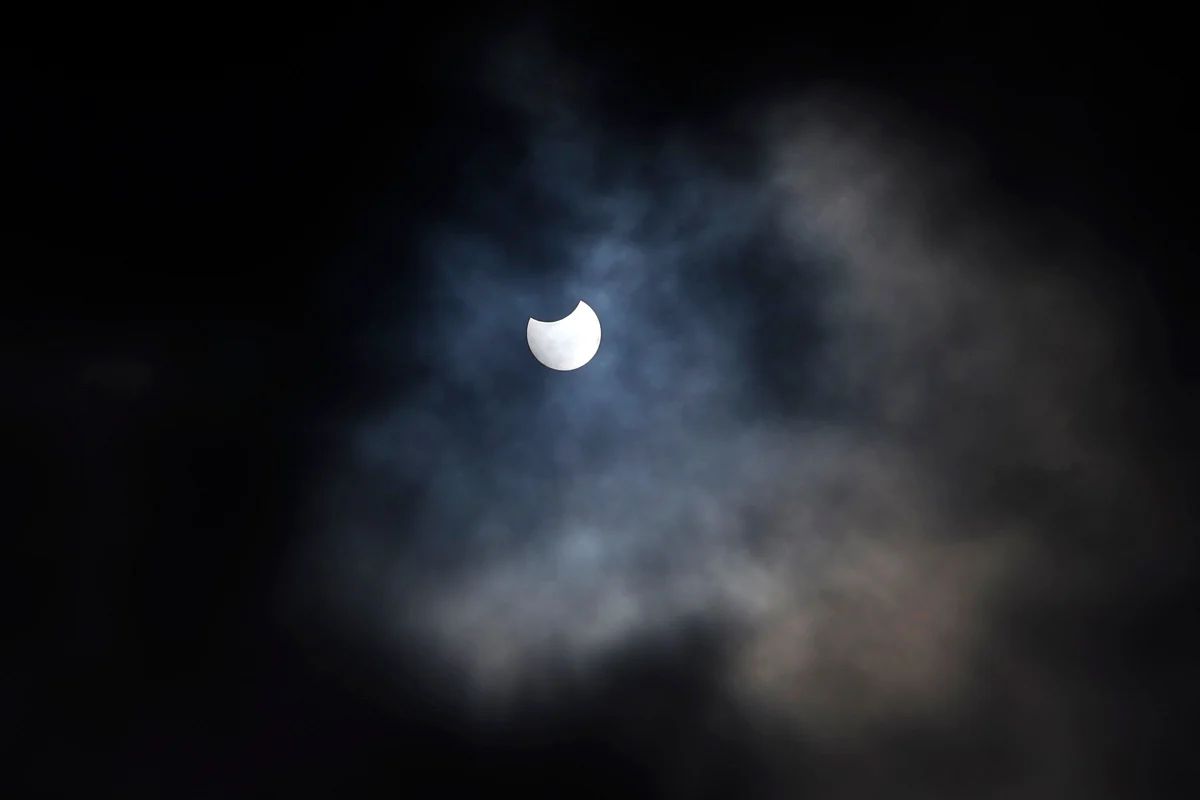A partial solar eclipse is seen through cloud cover from Primrose Hill in central London on June 10, 2021.