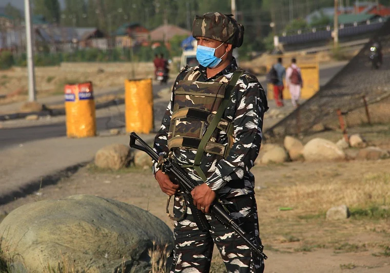 CRPF personnel stands guard on a road in outskirts of Srinagar