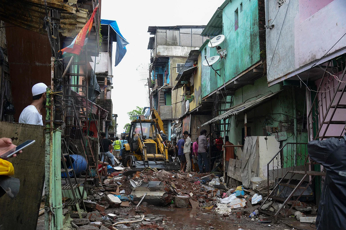 Civil authority and rescue personnel search for survivors in the debris of a building that collapsed following heavy monsoon rains, in Mumbai on June 10, 2021.