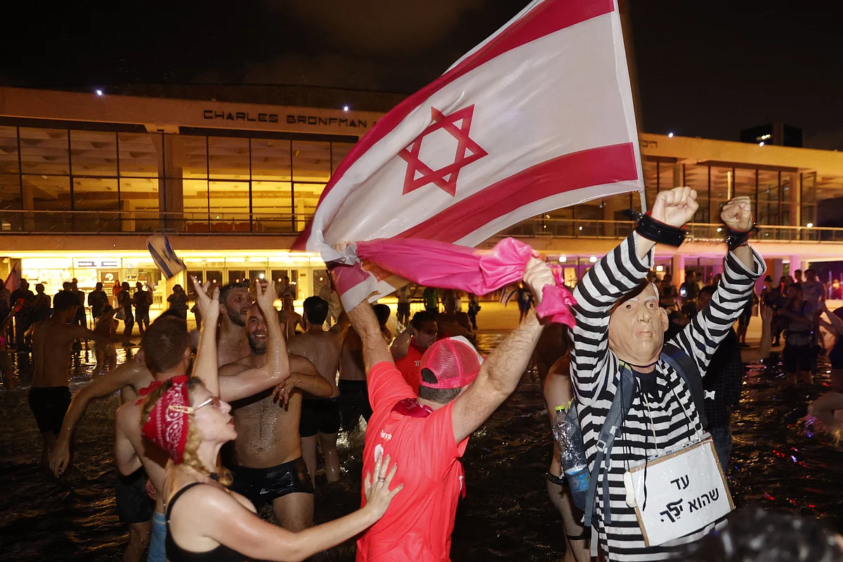 Israeli celebrate the passing of a Knesset vote confirming a new coalition government during a rally in Rabin Square in the Mediterranean coastal city of Tel Aviv on June 13, 2021.