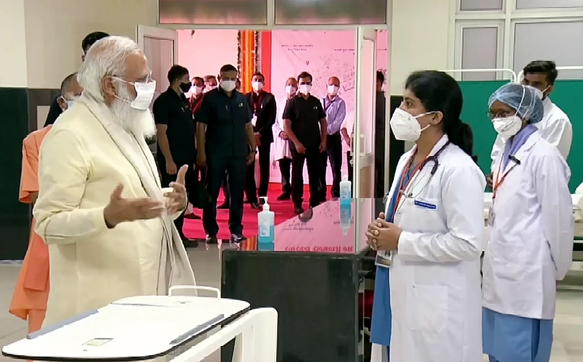 Prime Minister Narendra Modi interacts with the doctors during his visit to the 100-bed maternal & child health wing at Banaras Hindu University, in Varanasi on Thursday.