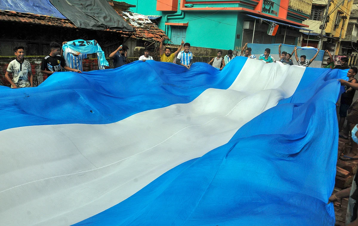 Argentina football fans celebrate with the team flag for their victory over Brazil in the Copa America Soccer final match, in Kolkata, Sunday, July 11, 2021.