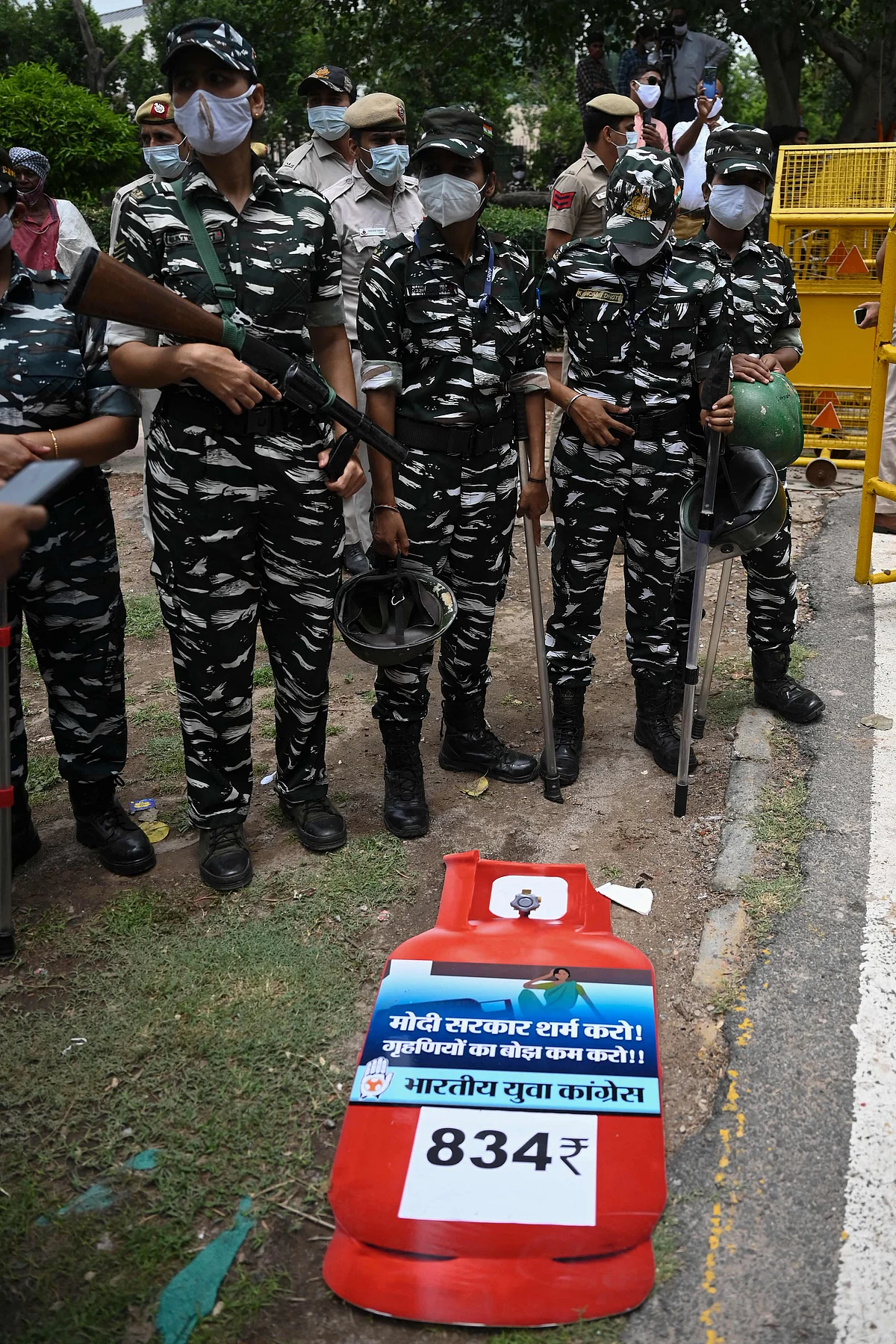 Security personnel stand guard as activists of the Indian Youth Congress (IYC) party (not seen) shout slogans during a protest against the recent price hike of fuel and Liquefied Petroleum Gas (LPG) cylinder, outside the ministry of petroleum and natural gas in New Delhi on July 3, 2021.