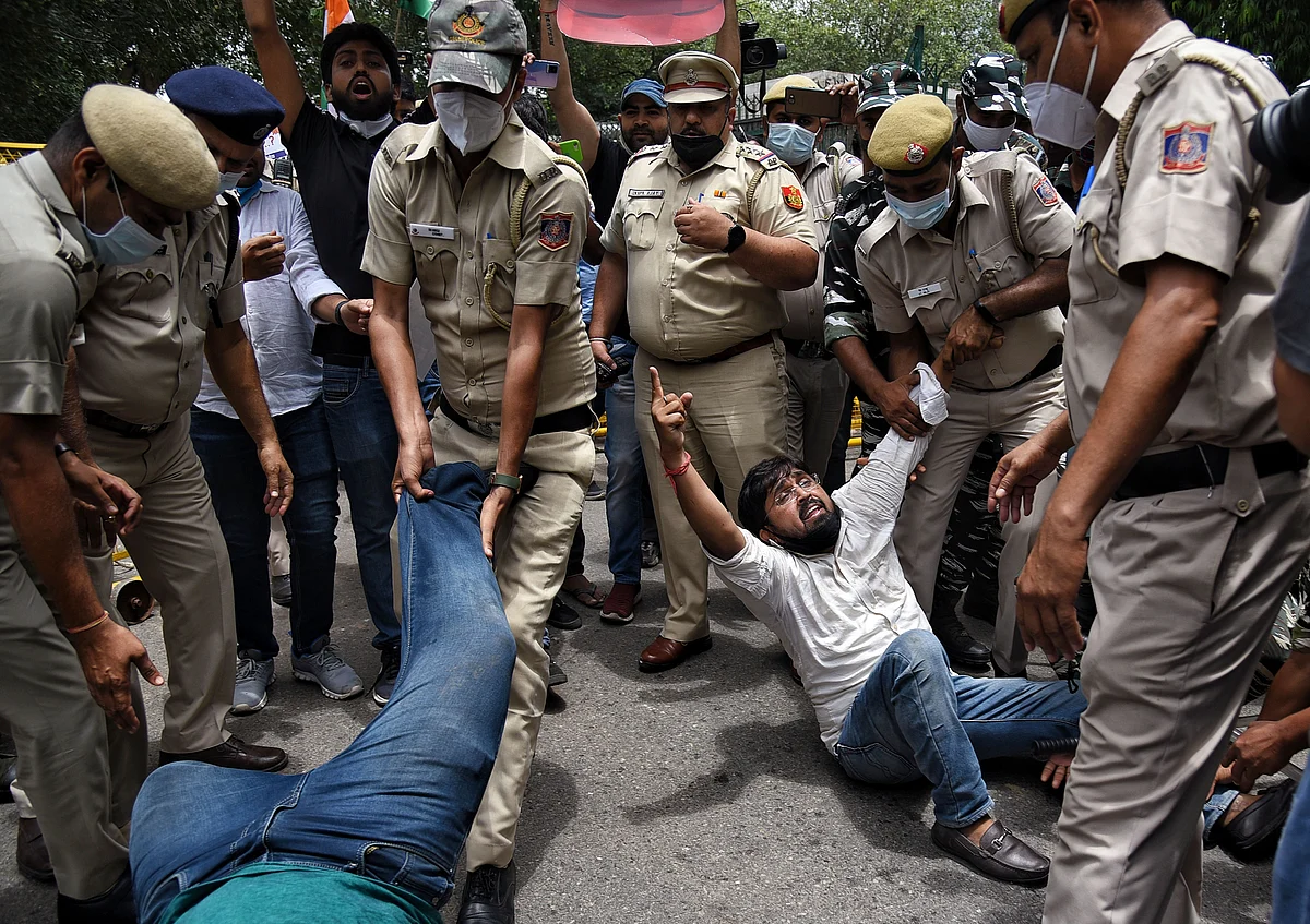 Security personnel detain the supporters of Indian Youth Congress (IYC) during a protest against the hike in fuel prices outside Shastri Bhawan, in New Delhi on Saturday.