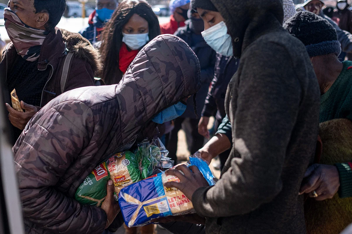 Residents of Soweto buy bread from a truck as shops and malls in Soweto are looted and closed for business on July 14, 2021.