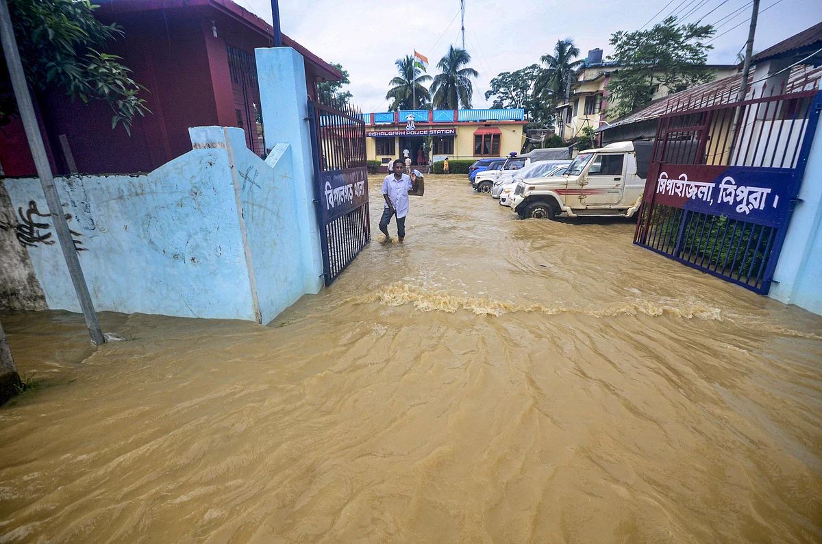 A villager wades through a flooded street after heavy rain in Bishalghar village on the outskirts of Agartala, Thursday, July 1, 2021.