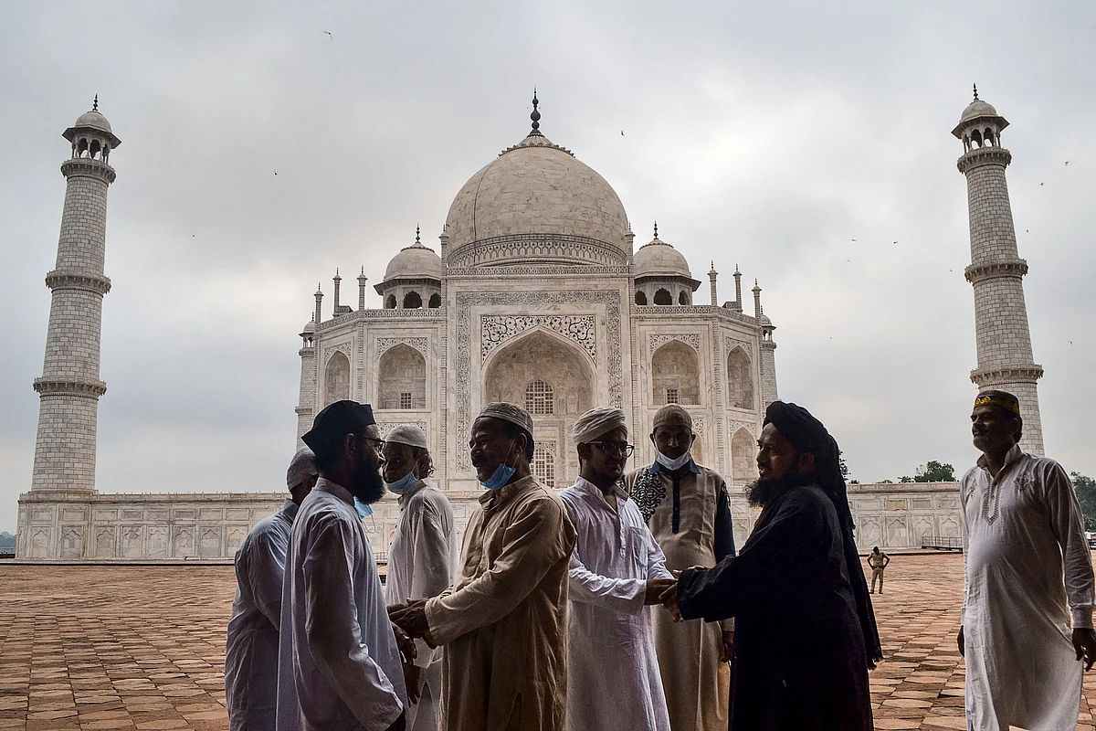 Muslim devotees greet as they arrive to offer prayers to mark the start of the Muslim festival Eid al-Adha or the Festival of Sacrifice, at the Taj Mahal in Agra on July 21, 2021.