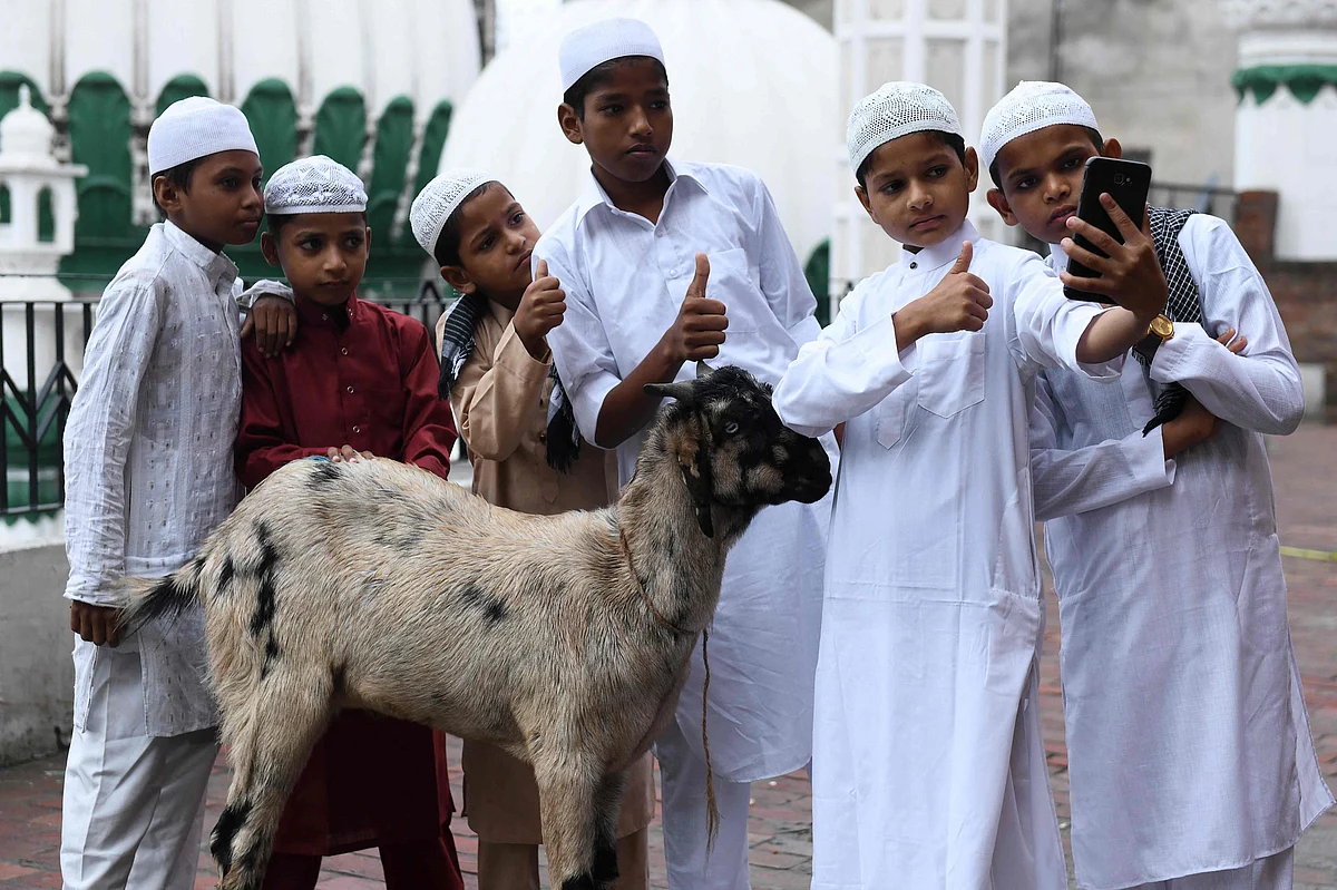 Young Muslim devotees take selfie pictures during the Eid al-Adha or the Festival of Sacrifice, at Jama Masjid Khairuddin in Amritsar on July 21, 2021.