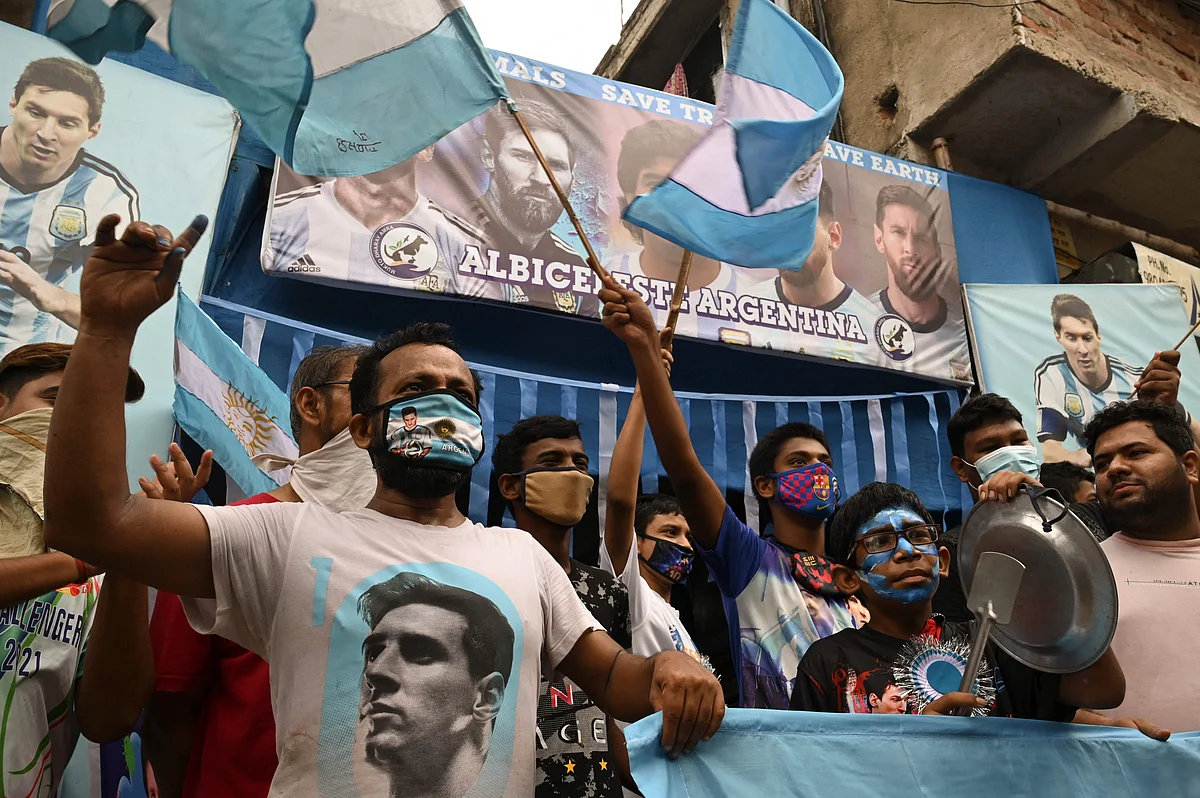 Argentina football fans hold national flags as they celebrate after winning the Conmebol 2021 Copa America football tournament final match against Brazil, in Kolkata on July 11, 2021.