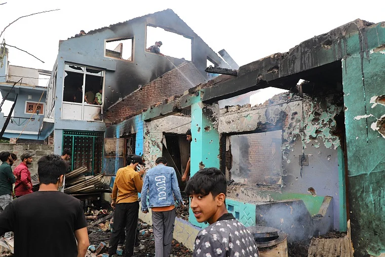 Kashmiri villagers inspect a house damaged in a gunfight in Pulwama, south of Srinagar