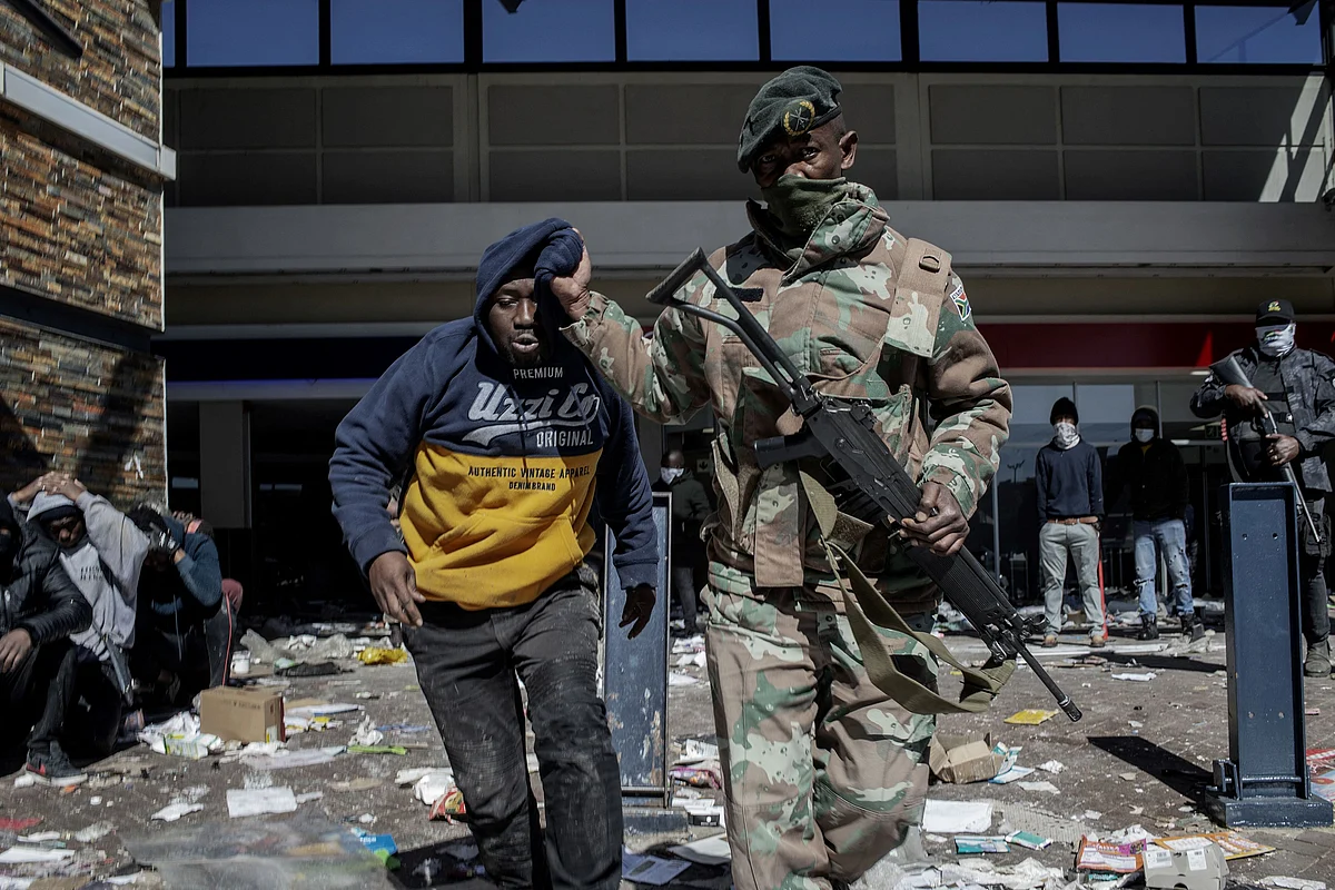 A South Africa National Defence Force (SANDF) soldier detains a suspected looter at Jabulani Mall in Soweto on July 13, 2021.