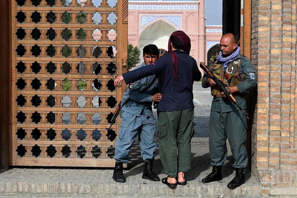 An Afghan security personnel frisks a devotee at the entrance of a mosque during the Eid al-Adha prayers in Kabul on July 20, 2021.