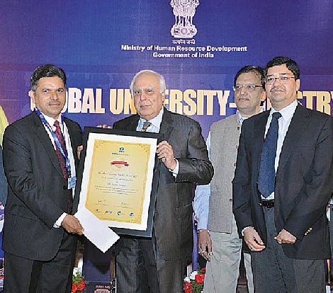 Dr Pednekar (left) receiving the award from Kapil Sibal, Minister of Communications and Information Technology and Sanjiv Lal, Vice President, Corporate Projects Tata Chemicals. In the background – Dr S S Mantha, AICTE Chairman