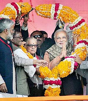 BJP PM candidate Narendra Modi is garlanded along with senior leader MM Joshi at an election campaign rally in Varanasi on Friday.