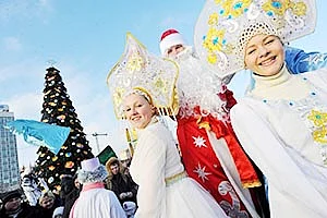 A little boy poses for photos with a Christmas tree in the Taipei.<br />RIGHT: Men wearing costumes of Ded Moroz (Grandfather Frost), the Santa Claus in Russia, Belarus and Ukraine, and women wearing costumes of Snegurochka<br />(Snow Maiden), the traditional companion of Ded Moroz, smile during their parade in Minsk.