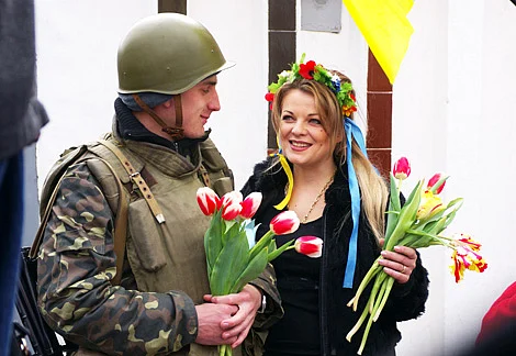 A girl presents flowers to a soldier of Ukrainian army on monday.