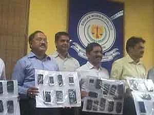 A police team displays the stolen mobile phones which were seized from the three youngsters after the raid