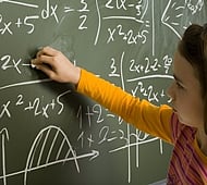 11yo girl are writting maths using chalk on greenboard.