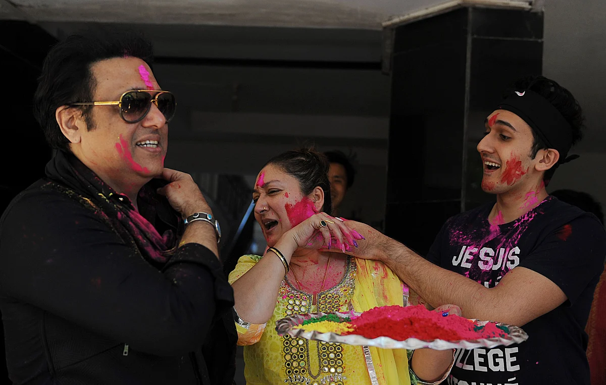 Indian Bollywood actor Govinda (L) with his wife (C) Sunita and son Yashvardhan Ahuja (R) take part in celebrations to mark the Hindu festival of Holi in Mumbai