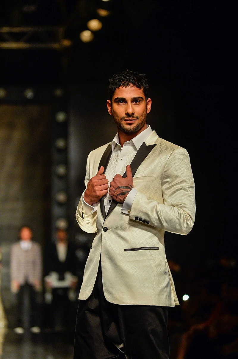 Indian actor Prateik Babbar presents a creation by Indian designers Kommal and Ratul Sood during the Amazon India Fashion Week Autumn Winter 2017 in New Delhi. / AFP PHOTO / CHANDAN KHANNA