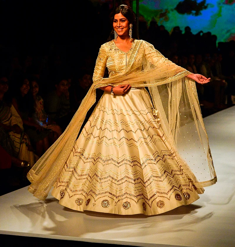 Indian television and film actress Sakshi Tanwar presents a creation by Indian designer Anju Modi during the Amazon India Fashion Week Autumn Winter 2017 on March 17, 2017 in New Delhi. / AFP PHOTO / CHANDAN KHANNA