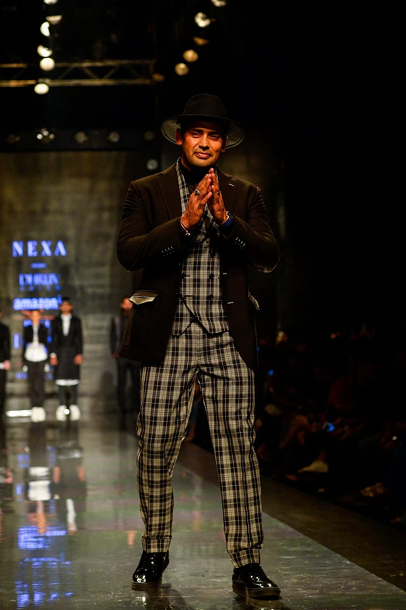 Indian wrestler and actor, Sangram Singh presents a creation by Indian designer Dhruv Vaish during the Amazon India Fashion Week Autumn Winter 2017 in New Delhi. / AFP PHOTO / CHANDAN KHANNA