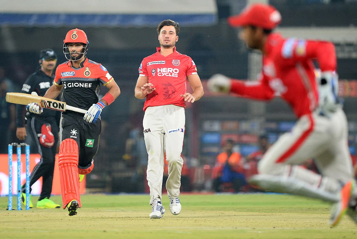 Royal Challengers Bangalore batsman Mandeep Singh (L) runs between the wickets as Kings XI Punjab bowler Marcus Stoinis (C) and wicketkeeper Wriddhiman Saha looks on during the 2017 Indian Premier League (IPL) Twenty20 cricket match between Kings XI Punjab and Royal Challengers Bangalore at the Holkar Stadium in Indore on April 10, 2017. —-IMAGE RESTRICTED TO EDITORIAL USE – STRICTLY NO COMMERCIAL USE—– / AFP PHOTO / SAJJAD HUSSAIN / —-IMAGE RESTRICTED TO EDITORIAL USE – STRICTLY NO COMMERCIAL USE—– / GETTYOUT