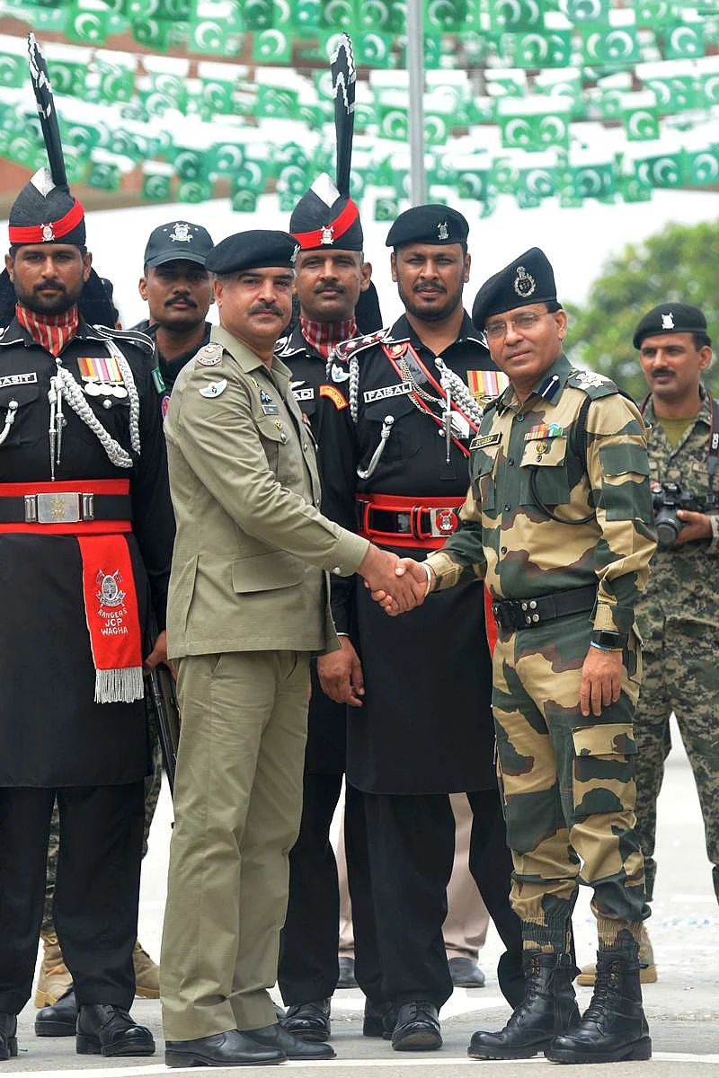 Pakistani Wing Commander Bilal (2L) shakes hand with the Indian Border Security Force (BSF) Commandant Sudeep (2R) during a ceremony to celebrate Pakistan’s Independence Day at the India-Pakistan Wagah border post on August 14, 2017. / AFP PHOTO / NARINDER NANU