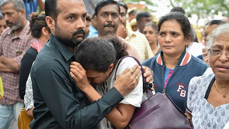Indian journalist Gauri Lankesh’s sister Kavitha Lankesh (C) is consoled by a relative as her body to brought to the Ravindra Kalakshetra cultural centre in Bangalore on September 6, 2017./ AFP PHOTO / MANJUNATH KIRAN