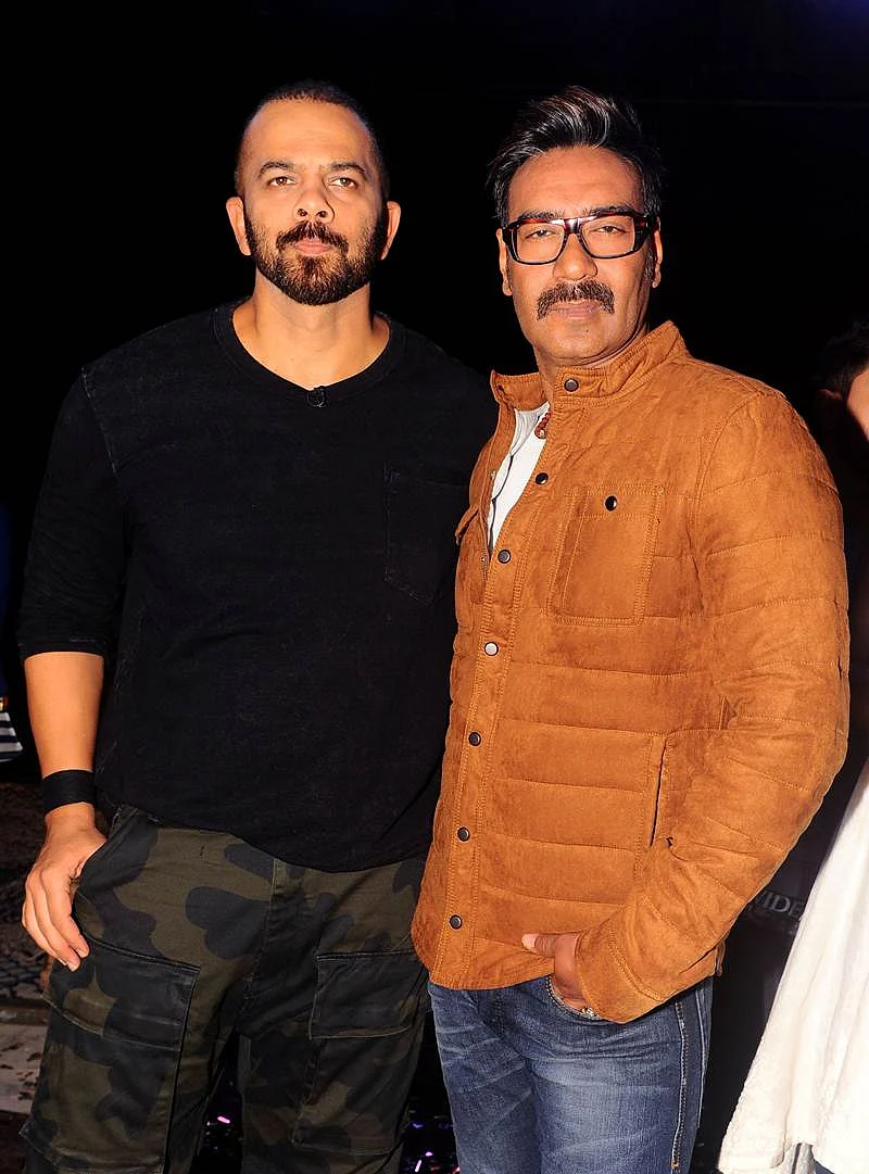 Indian Bollywood director Rohit Shetty (L) and actor Ajay Devgn pose for a photograph during a promotional event for the ‘Khatron Ke Khiladi’ reality show, based on the US format ‘Fear Factor’ in Mumbai on late September 19, 2017. / AFP PHOTO / STR