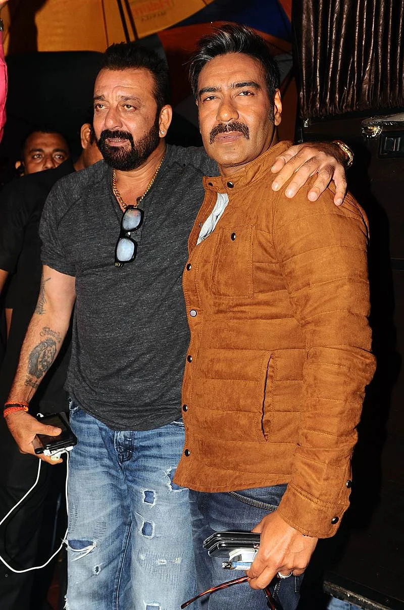 Indian Bollywood actors Sanjay Dutt (L) and Ajay Devgn pose for a photograph during a promotional event for the ‘Khatron Ke Khiladi’ reality show, based on the US format ‘Fear Factor’ in Mumbai on late September 19, 2017. / AFP PHOTO / STR
