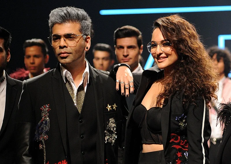 Indian Bollywood film director Karan Johar (L) and actress Sonakshi Sinha (R) showcase creations by designer Falguni Shane Peacock at the Lakmé Fashion Week (LFW) Summer Resort 2018 in Mumbai on February 2, 2018.