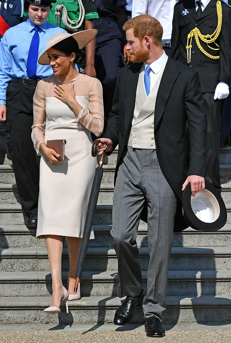 Britain’s Prince Harry, Duke of Sussex (R), and his new wife, Britain’s Meghan, Duchess of Sussex, attend the Prince of Wales’s 70th Birthday Garden Party at Buckingham Palace in London. / AFP PHOTO / POOL / Dominic Lipinski