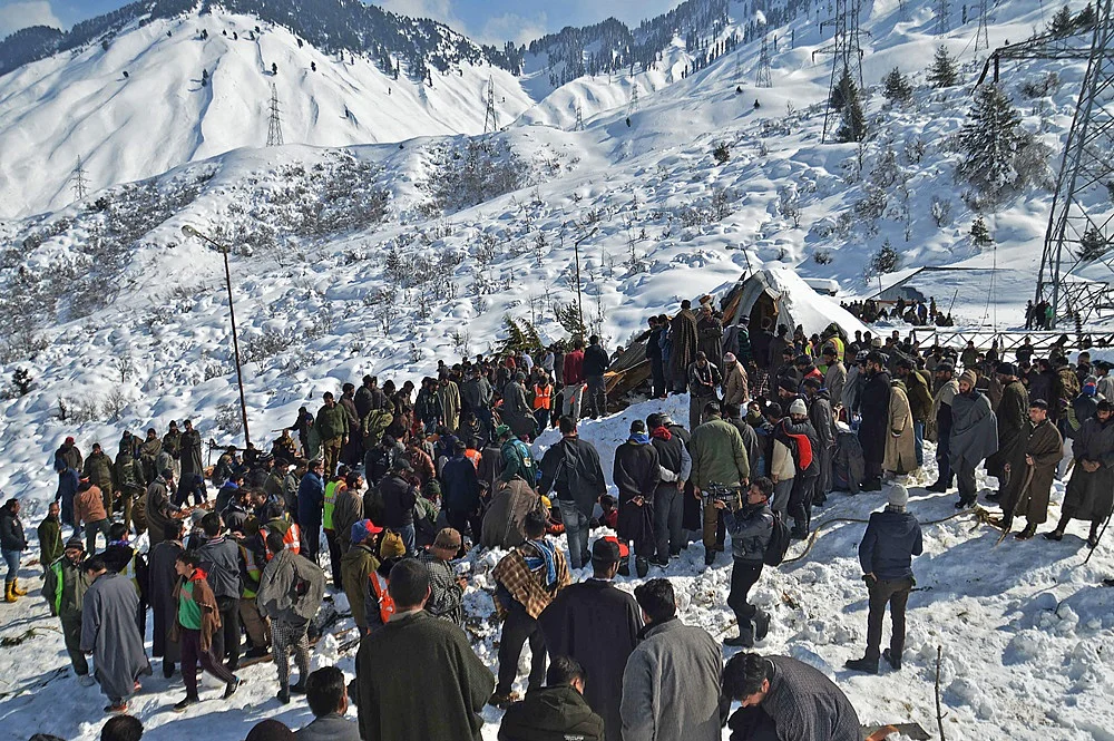 Local residents along with security personnel search the bodies of 10 missing policemen after a snow avalanche hit a police post at Qazigund Jawahar Tunnel in Kulgam district, some 90 km from Srinagar.<br />Photo by STR / AFP
