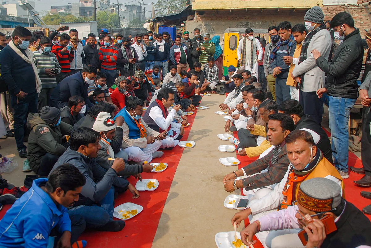 BJP MLA Pankaj Singh (5L) having a meal with the residents of a locality on Makar Sankranti, in Noida, Thursday, Jan. 14, 2021. (PTI Photo)
