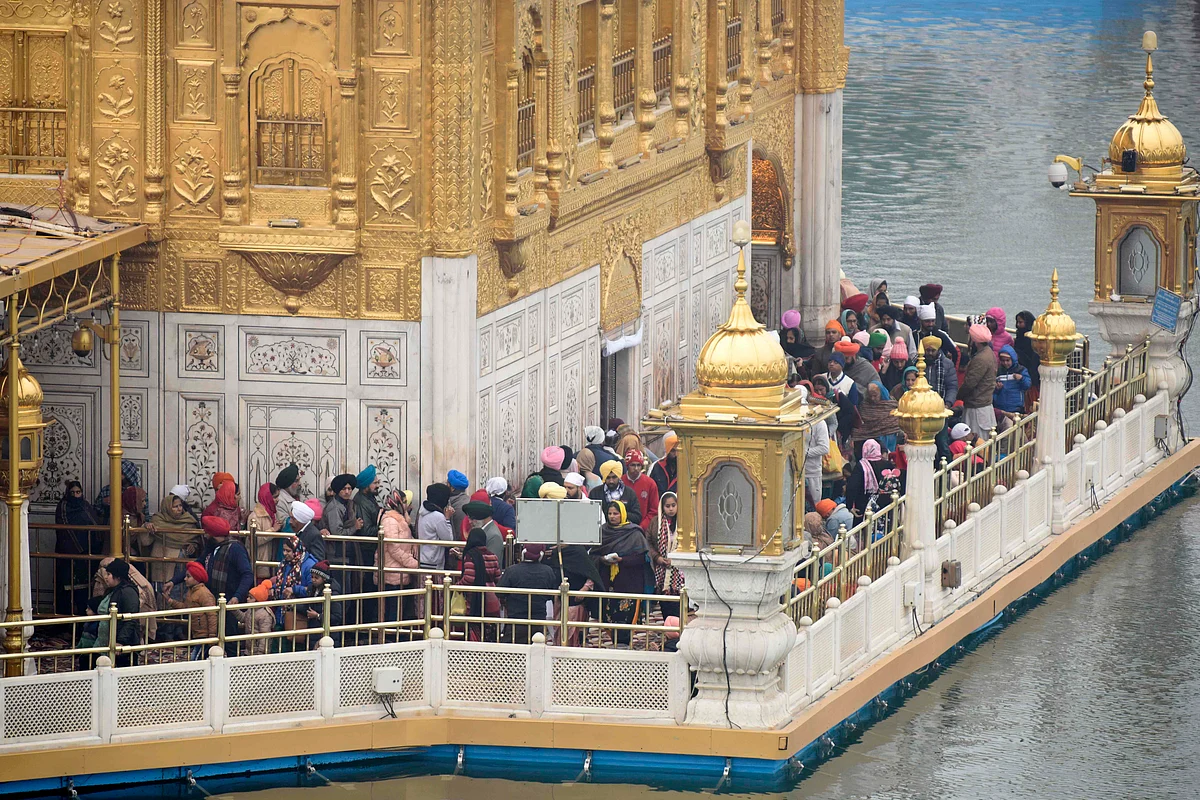 Sikh devotees stand in queues to pay their respect on the occasion of Maghi Mela festival, following the Lohri or harvest festival at the Golden Temple in Amritsar on January 14, 2021.