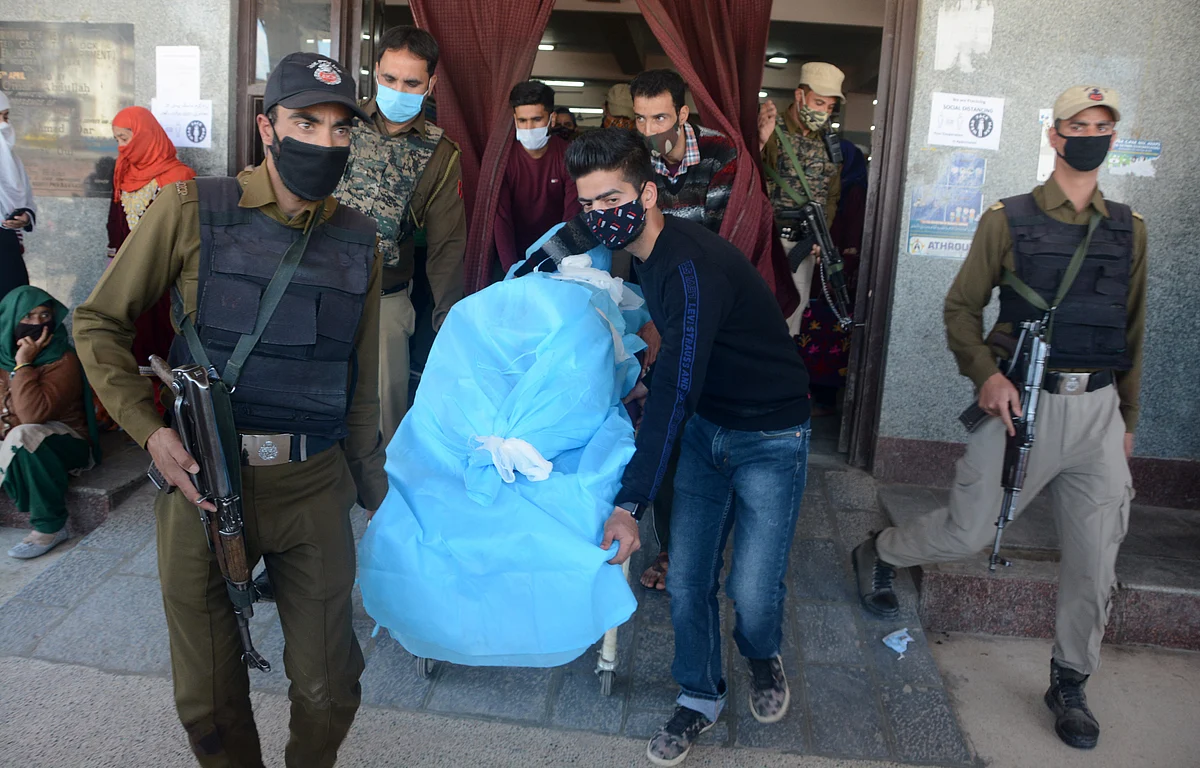People carrying the succumbed police cop on a stretcher at a hospital in Srinagar, Kashmir.