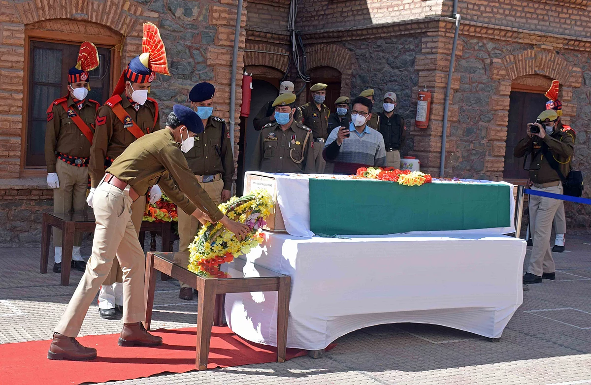 A senior police officer lays a wreath on the coffin containing the body of the slain policeman Rameez Ahmed Itoo during the wreath-laying ceremony at the police headquarters, in Srinagar.