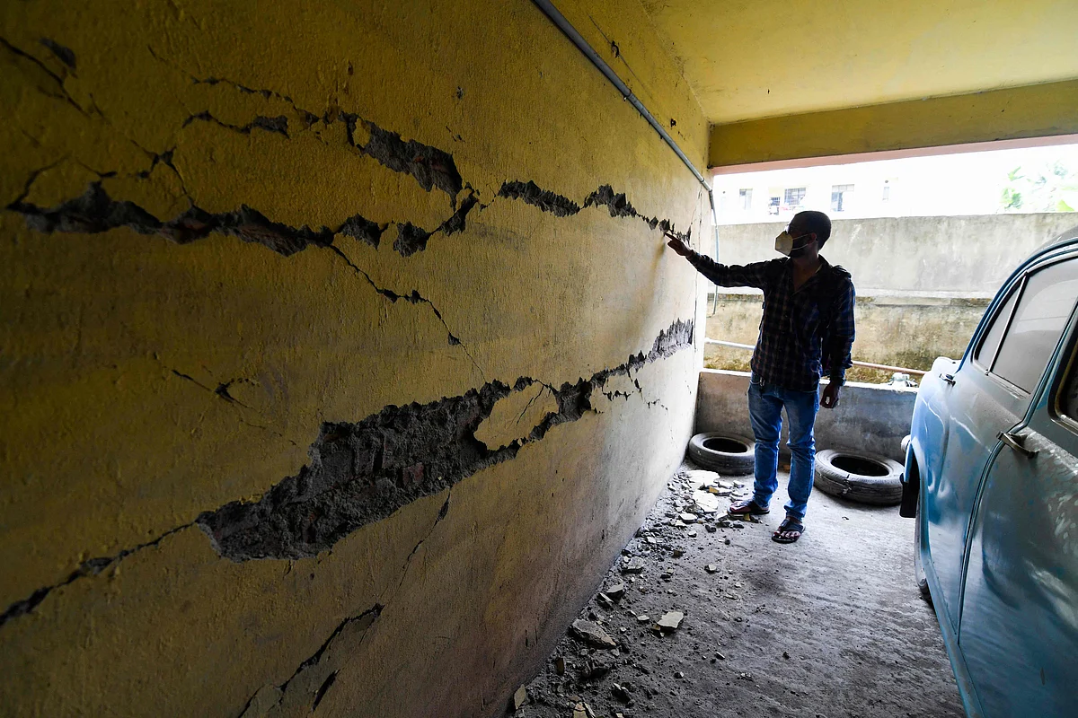 A man looks at cracks on a wall at an apartment building in Guwahati on April 28, 2021, after a strong earthquake hit Assam in northeastern India, damaging buildings.